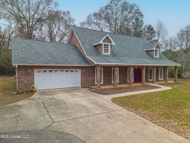 cape cod house with a garage, a front yard, and covered porch