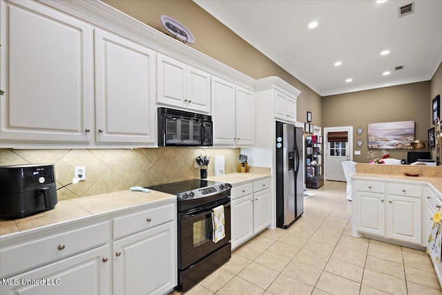 kitchen featuring white cabinetry, tasteful backsplash, tile counters, ornamental molding, and black appliances