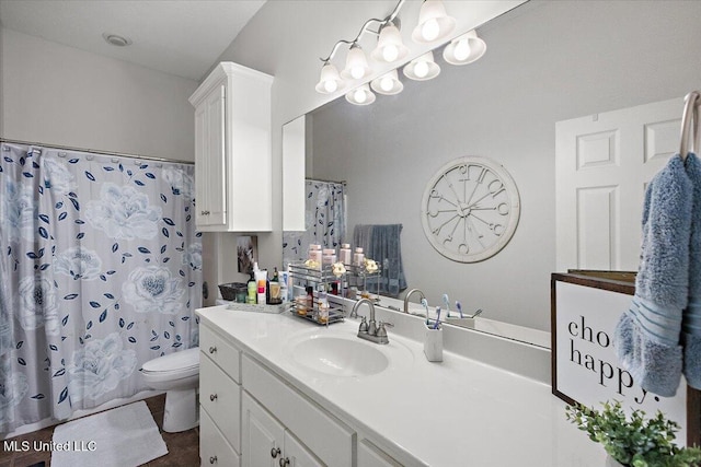 bathroom featuring vanity, curtained shower, and toilet