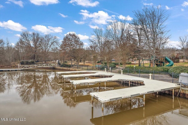 view of dock featuring a playground and a water view