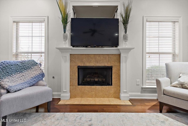 living room with a tile fireplace and hardwood / wood-style floors