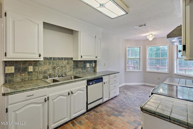 kitchen featuring visible vents, a sink, dishwasher, and tile counters