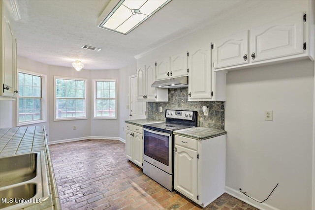 kitchen featuring stainless steel range with electric stovetop, tile counters, white cabinetry, backsplash, and under cabinet range hood