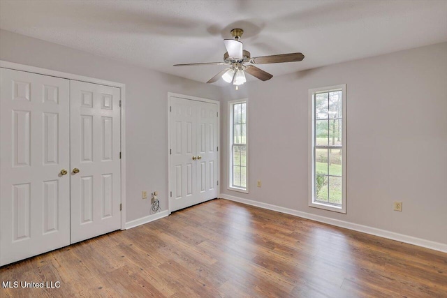 entrance foyer with baseboards, ceiling fan, and wood finished floors