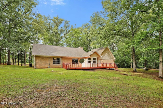 back of house featuring a yard, a wooden deck, and a chimney
