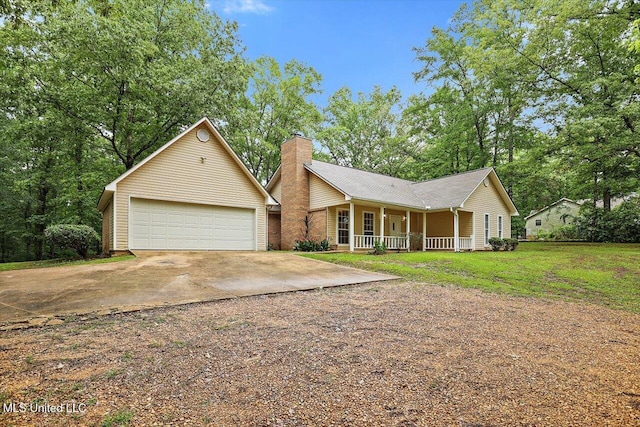 view of front of house with a detached garage, a chimney, a porch, and a front lawn