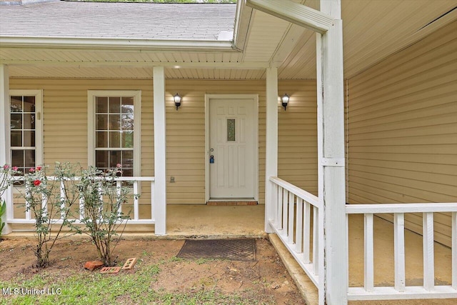 property entrance with a porch and roof with shingles