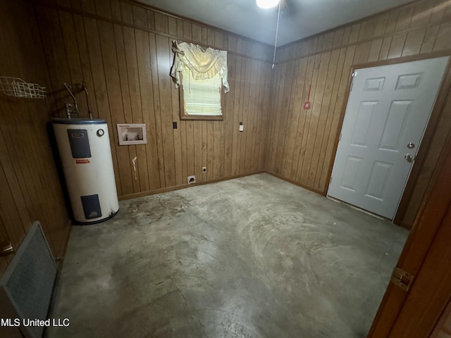 221 S Oak Ave, Ruleville, MS 38771 - unfurnished room featuring electric water heater, unfinished concrete flooring, and wooden walls