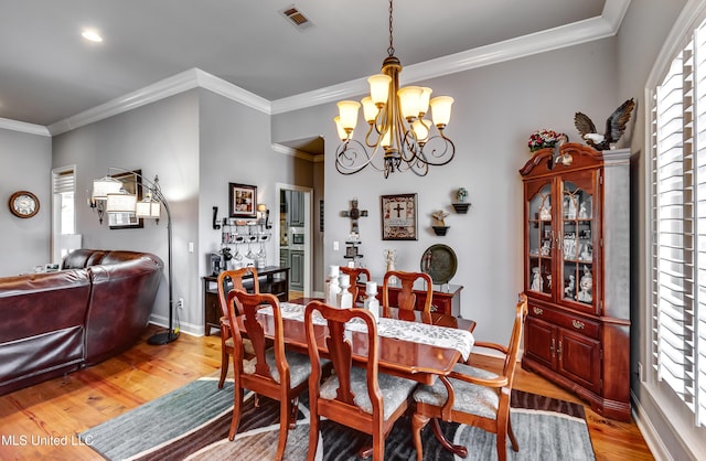 dining area with light wood-style floors, a wealth of natural light, and a chandelier