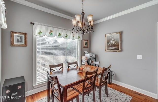 dining area with crown molding, wood finished floors, a healthy amount of sunlight, and a chandelier