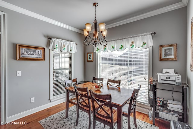 dining space with an inviting chandelier, wood finished floors, baseboards, and ornamental molding