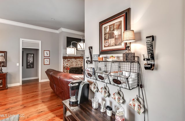 living room with baseboards, light wood-style floors, and ornamental molding