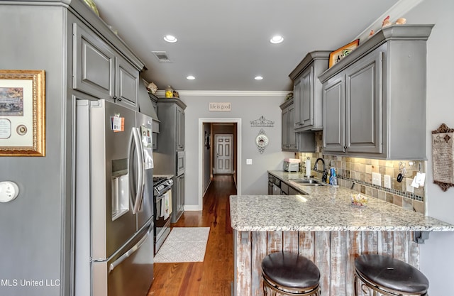 kitchen featuring visible vents, stainless steel fridge, and gray cabinets