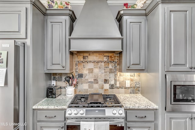 kitchen featuring backsplash, stainless steel appliances, custom exhaust hood, and gray cabinets