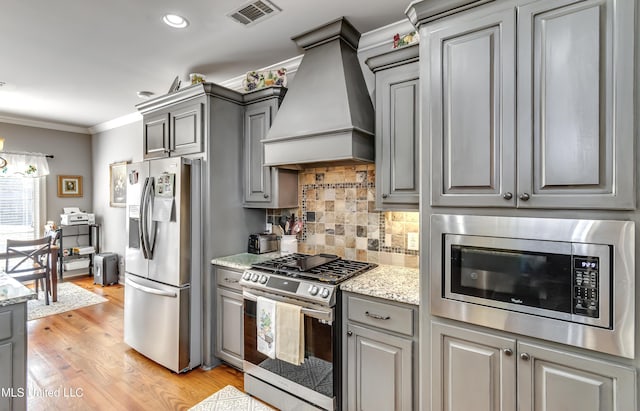 kitchen featuring custom exhaust hood, gray cabinetry, visible vents, and stainless steel appliances