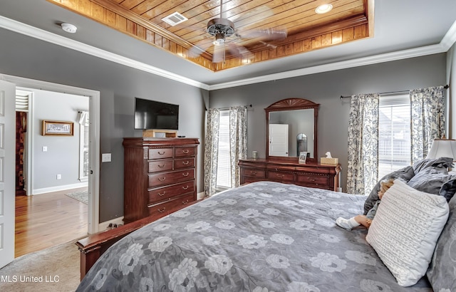 bedroom with a tray ceiling, visible vents, wooden ceiling, and ornamental molding