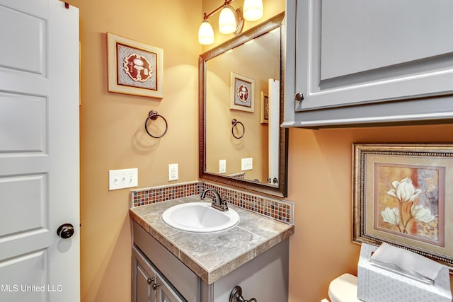 bathroom featuring backsplash, vanity, and toilet