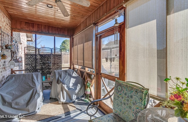 sunroom / solarium with wood ceiling and a ceiling fan