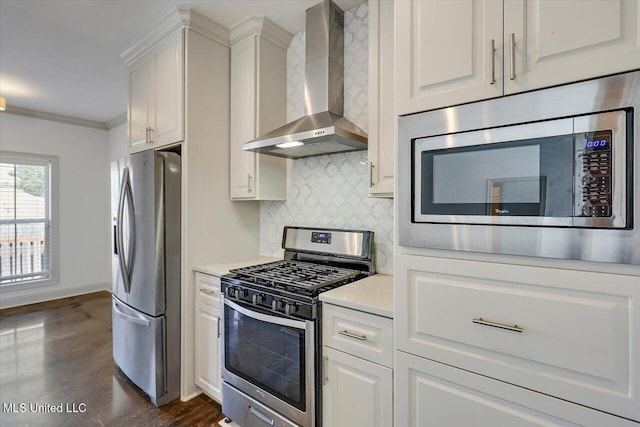 kitchen featuring wall chimney range hood, backsplash, stainless steel appliances, and white cabinetry