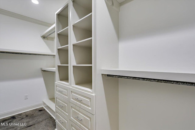 walk in closet with dark colored carpet