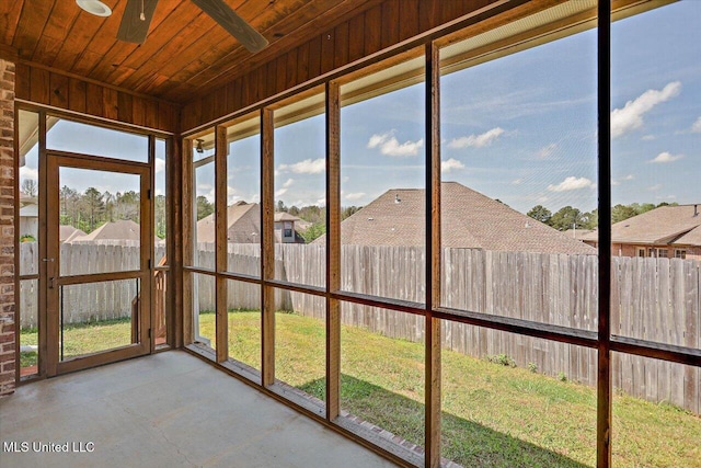 unfurnished sunroom featuring ceiling fan and a healthy amount of sunlight