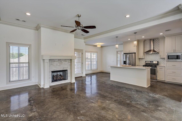 kitchen with visible vents, ornamental molding, open floor plan, wall chimney range hood, and stainless steel appliances