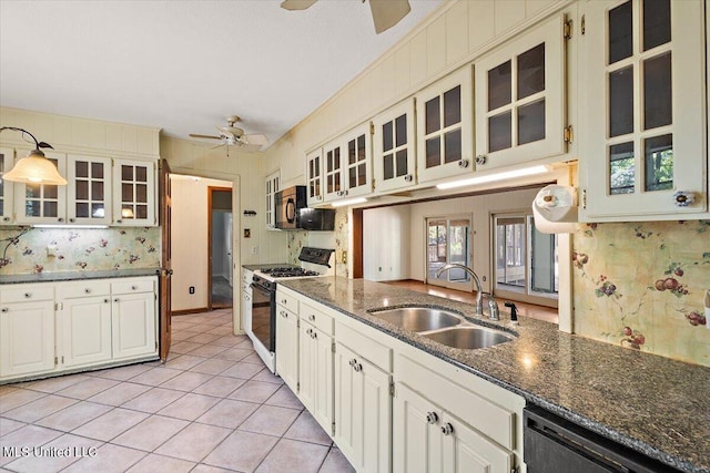 kitchen featuring stainless steel appliances, sink, light tile patterned floors, white cabinetry, and decorative light fixtures