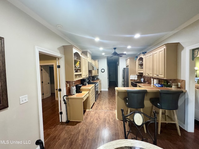 856 Wellington Way, Madison, MS 39110 - kitchen featuring appliances with stainless steel finishes, a ceiling fan, a kitchen breakfast bar, dark wood-type flooring, and cream cabinets