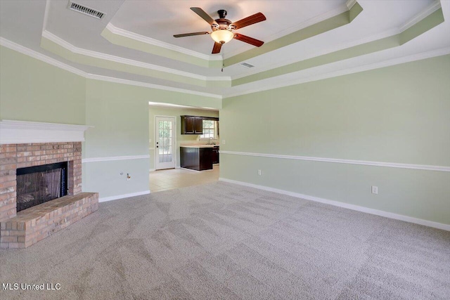 4328 Blaine Cir, Byram, MS 39272 - unfurnished living room with a raised ceiling, light carpet, ornamental molding, ceiling fan, and a brick fireplace