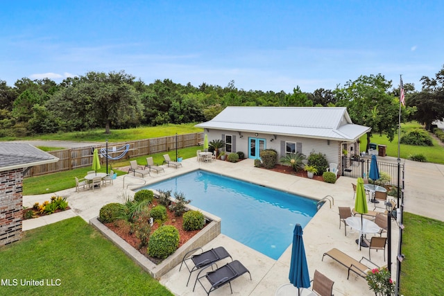 view of swimming pool with french doors, a yard, and a patio area