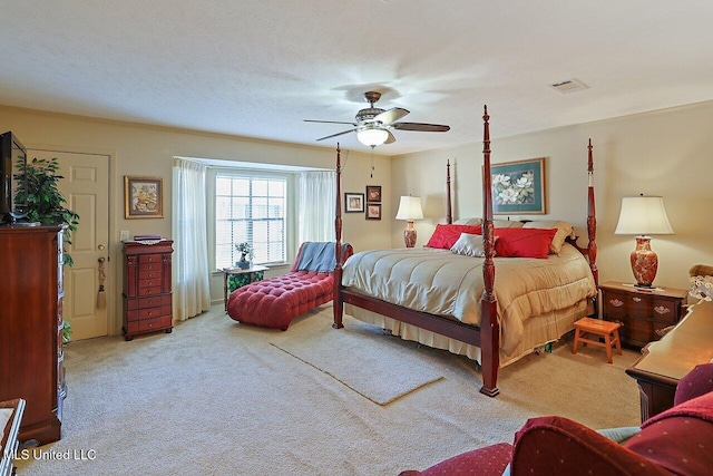 carpeted bedroom featuring ceiling fan, visible vents, and a textured ceiling