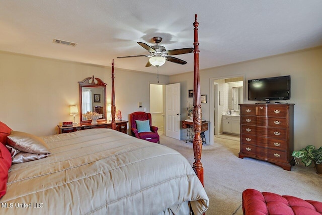 bedroom featuring ensuite bathroom, a ceiling fan, visible vents, and light colored carpet