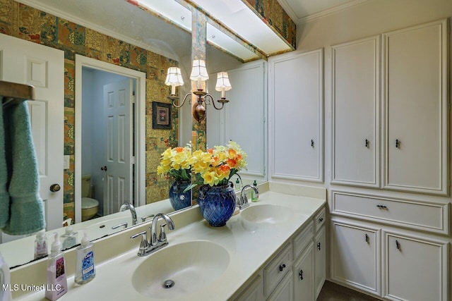 bathroom with double vanity, an inviting chandelier, toilet, and a sink