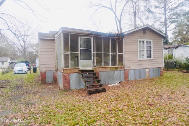 rear view of property with a sunroom