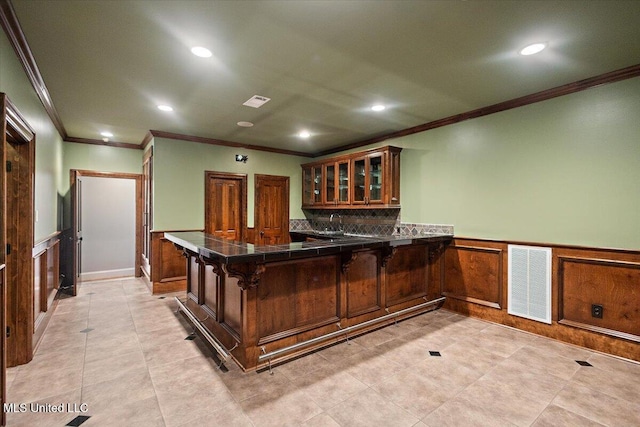 12025 Springridge Rd, Terry, MS 39170 - kitchen with crown molding, a peninsula, a wainscoted wall, glass insert cabinets, and recessed lighting