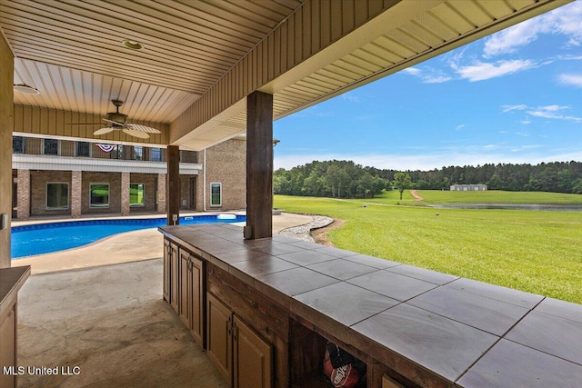 12025 Springridge Rd, Terry, MS 39170 - view of patio / terrace with a ceiling fan, an outdoor pool, and a water view