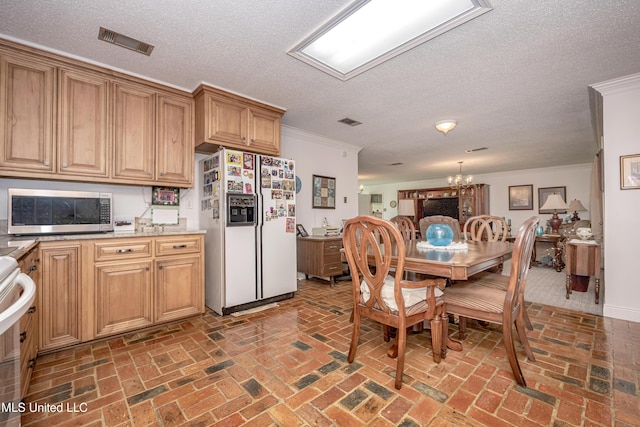 10001 Echo Glen Dr, Moss Point, MS 39562 - kitchen with white fridge with ice dispenser, stainless steel microwave, brick flooring, ornamental molding, and a textured ceiling
