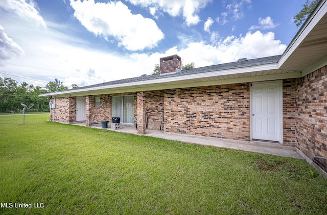 10001 Echo Glen Dr, Moss Point, MS 39562 - back of house featuring brick siding, a lawn, a chimney, and a patio area