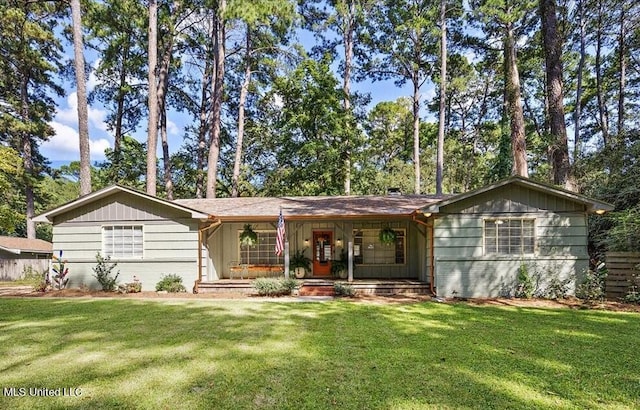 single story home featuring covered porch, brick siding, and a front yard