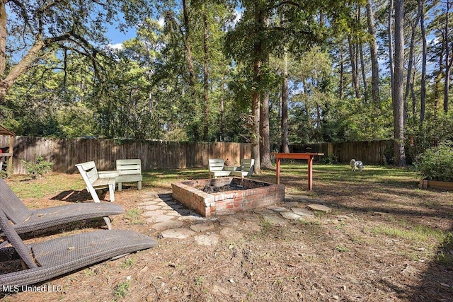 view of yard featuring a fire pit and a fenced backyard