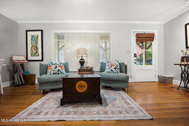 living area featuring crown molding, baseboards, and wood finished floors