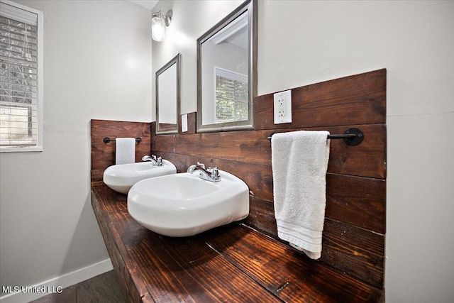 bathroom featuring plenty of natural light, baseboards, and a sink