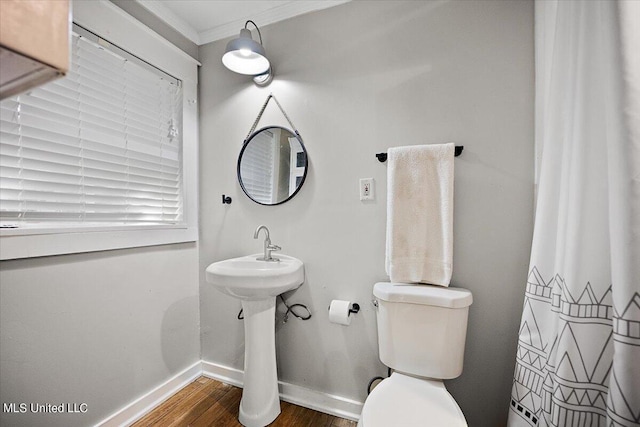 full bath with crown molding, toilet, baseboards, and wood finished floors