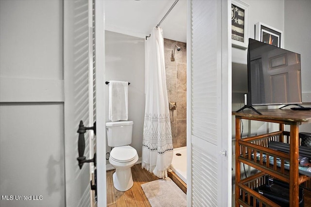 bathroom with toilet, walk in shower, and wood-type flooring