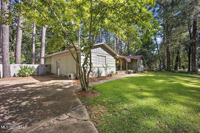 view of property exterior featuring a yard, fence, and driveway