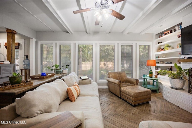 sunroom featuring a wealth of natural light, beam ceiling, and ceiling fan