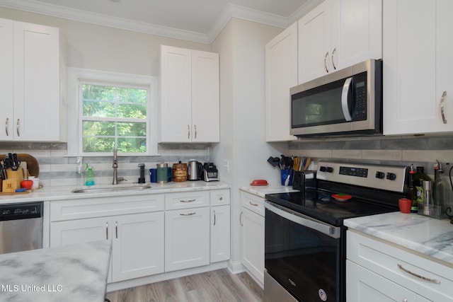13 High Hills Dr, Hattiesburg, MS 39402 - kitchen featuring stainless steel appliances, a sink, decorative backsplash, white cabinets, and crown molding