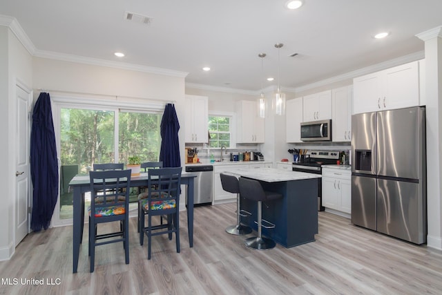 13 High Hills Dr, Hattiesburg, MS 39402 - kitchen featuring appliances with stainless steel finishes, a center island, white cabinets, light wood-style flooring, and a sink