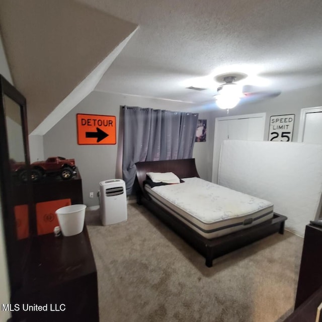 bedroom with ceiling fan, carpet, and a textured ceiling