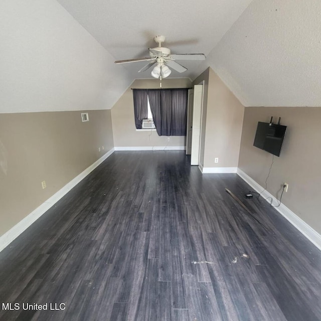 additional living space featuring ceiling fan, dark hardwood / wood-style flooring, cooling unit, a textured ceiling, and vaulted ceiling